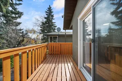a wooden deck with a sliding glass door at Spacious 4-Bedroom Retreat Near Bow River with Foosball, Dart Board, Movie Room in Calgary