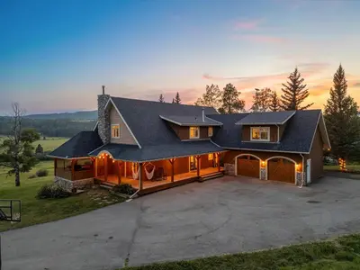 a house with a driveway and a garage at Rolling Hills Retreat - Family Friendly in Millarville