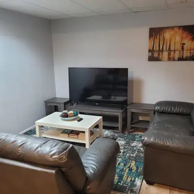 a living room with two leather couches and a tv at Fabulous Room in Edmonton