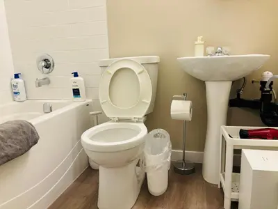 a bathroom with a white toilet and a sink at Walkout Basement Suite with Free Street Parking in Calgary