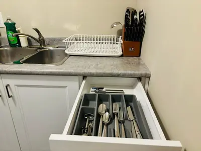 a kitchen counter with a drawer filled with utensils at Walkout Basement Suite with Free Street Parking in Calgary
