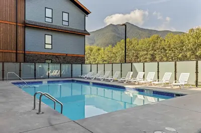 a swimming pool with chairs and a house at Outdoor heated pool and hot tub Stunning 3Bd sanctuary in Dead Man's Flats
