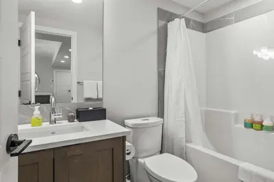 a white bathroom with a toilet and a sink at Outdoor heated pool and hot tub Stunning 3Bd sanctuary in Dead Man's Flats
