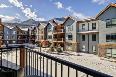 a balcony of a apartment building with snow on the ground at Pool and hot tub Stunning 2Bd haven in the Rockies in Dead Man's Flats