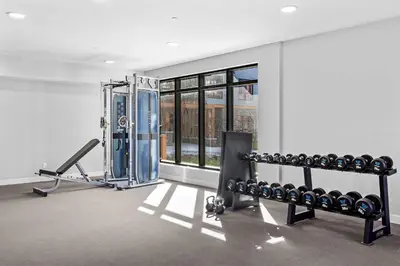 a room with a gym with a bunch of equipment at Pool and hot tub Stunning 2Bd haven in the Rockies in Dead Man's Flats