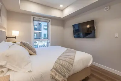 a bedroom with a white bed and a television at La Sombra at Sparrowhawk Lodge Brand New 2Bd in Dead Man's Flats