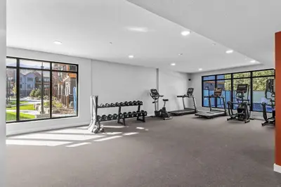 a gym with benches and ellipticals in a room with windows at La Sombra at Sparrowhawk Lodge Brand New 2Bd in Dead Man's Flats