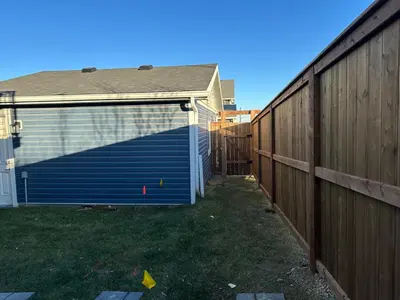 a garage with a blue door next to a fence at The Urban Nest in Calgary