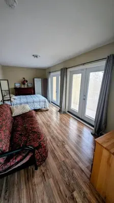 a living room with a bed and a wooden floor at Spacious West Kelowna Home that is great for family, friends, or business trip! in West Kelowna
