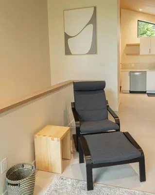 a living room with a chair and a stool at Calmwater Retreat New 2 br Hot Tub in Ucluelet