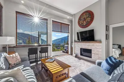 a living room with a couch and a fireplace at Powder Heights #15 home in Sun Peaks