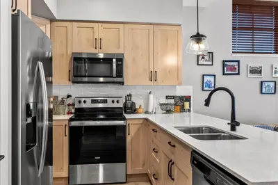 a kitchen with wooden cabinets and a stainless steel refrigerator at Powder Heights #15 home in Sun Peaks