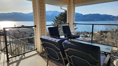a balcony with chairs and a view of the water at Peachland Lake View Spectacular! in Peachland