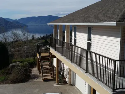 a balcony of a house with a view of a lake at Peachland Lake View Spectacular! in Peachland