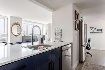 a kitchen with a sink and a refrigerator at Luxury 2 Bed 2 Bath Condo Downtown Vancouver with Free Parking in Vancouver