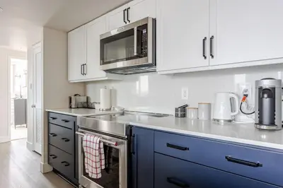 a kitchen with white cabinets and a stove top oven at Luxury 2 Bed 2 Bath Condo Downtown Vancouver with Free Parking in Vancouver