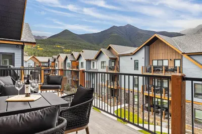 a balcony with a table and chairs and mountains at Perfect 3 bed-2 bath Top Floor Hot Tub Heated Pool Gym in Dead Man's Flats