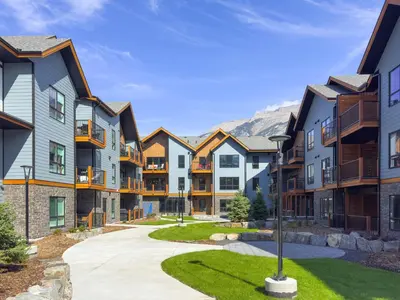a row of apartment buildings with mountains in the background at Perfect 3 bed-2 bath Top Floor Hot Tub Heated Pool Gym in Dead Man's Flats