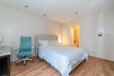 a bedroom with a bed and a blue chair at Garden Hotel 3-bedroom house for whole book in Richmond