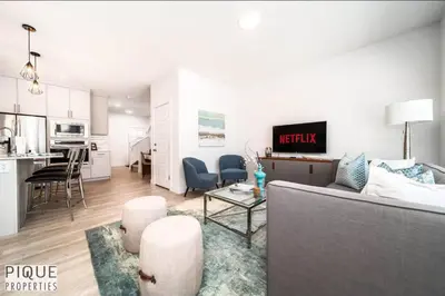 a living room and kitchen with a couch and a table at Modern Executive Home-Sleeps12-KingBeds-FullHouse in Edmonton