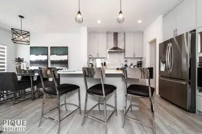 a kitchen with a table and chairs and a refrigerator at Modern Executive Home-Sleeps12-KingBeds-FullHouse in Edmonton