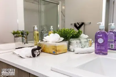 a bathroom counter with a sink and a mirror at Modern Executive Home-Sleeps12-KingBeds-FullHouse in Edmonton