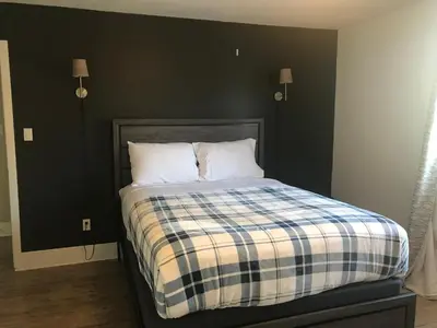 a bedroom with a bed with a black wall at Northern Rainbow Upper Level Suite in House in Yellowknife