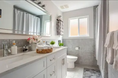 a bathroom with a sink and a toilet and a mirror at The Oxford Signature Luxury Entire Family Suite in Coquitlam