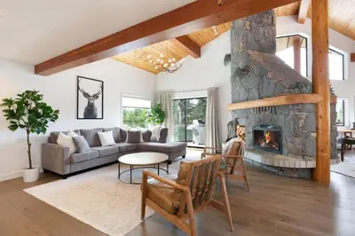 a living room with a couch and a fireplace at White Gold Chalet - Spacious Family-Friendly Chalet, Hot Tub, Mountain Views, Log Fireplace in Whistler