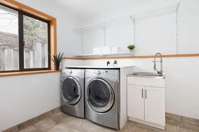 a kitchen with a washing machine and a sink at White Gold Chalet - Spacious Family-Friendly Chalet, Hot Tub, Mountain Views, Log Fireplace in Whistler