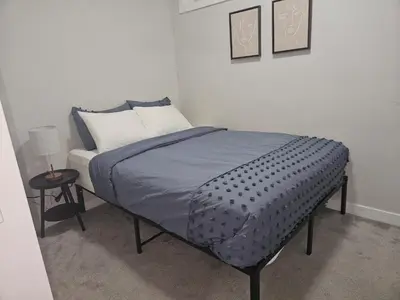 a bedroom with a bed and a side table at Wola's Place in Calgary