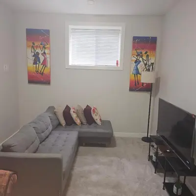 a living room with a couch and paintings on the wall at Wola's Place in Calgary