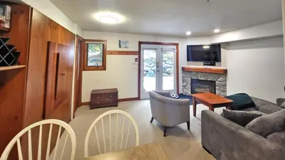 a living room with a couch and a fireplace at Timberline Village #12 home in Sun Peaks