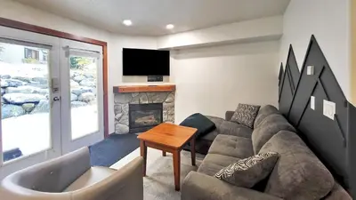 a living room with a couch and a fireplace at Timberline Village #12 home in Sun Peaks