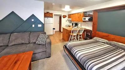 a living room with a couch and a kitchen at Timberline Village #12 home in Sun Peaks