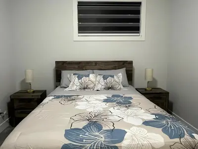 a bedroom with a bed with blue and white sheets at Arriva Homestay in Calgary
