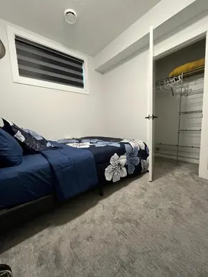 a bedroom with a bed and a closet at Arriva Homestay in Calgary