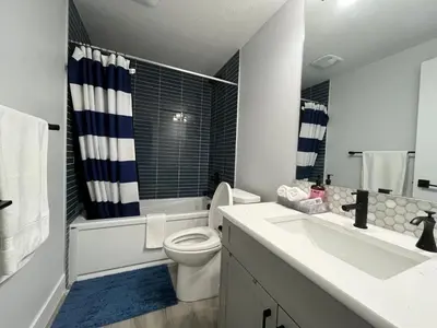 a bathroom with a toilet and a sink and a shower at Arriva Homestay in Calgary