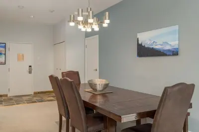 a dining room with a wooden table and chairs at Tantalus Penthouse Mountain and Village Views in Whistler