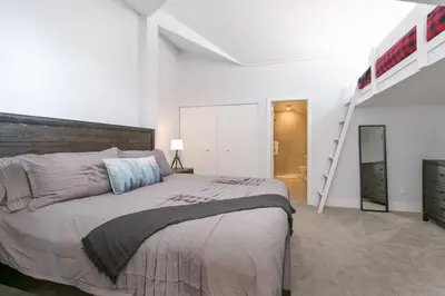 a bedroom with a large bed and a ladder at Tantalus Penthouse Mountain and Village Views in Whistler