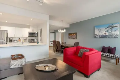 a living room with a red chair and a table at Black Tusk - Top Floor, Best Location, Mtn Views in Whistler