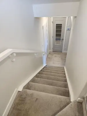 a staircase in a white room with a stair case at Luxury Cozy Basement in Leduc