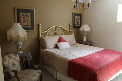 a bedroom with a bed and a chair and a lamp at Selah Retreat Guesthouse B&B in Sorrento