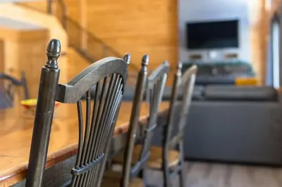 a group of chairs sitting around a wooden table at Snow Pines by StayIn in Fernie