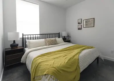 a bedroom with a large bed with a yellow blanket at The Brickworks at the 1896 Building in Kaslo