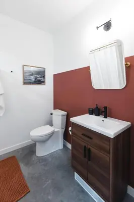 a bathroom with a toilet and a sink and a mirror at The Brickworks at the 1896 Building in Kaslo