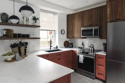 a kitchen with wooden cabinets and a stainless steel refrigerator at The Brickworks at the 1896 Building in Kaslo