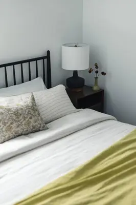 a bedroom with a bed with a lamp on a night stand at The Brickworks at the 1896 Building in Kaslo