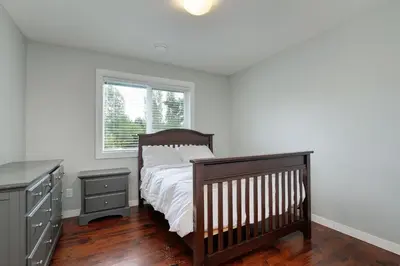 a bedroom with a bed and a dresser and a window at Modern Home in Victoria, BC in Victoria