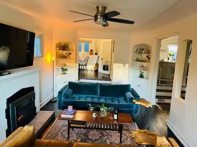 a living room with a blue couch and a fireplace at Hikari-Okanagan Sunshine B&B in Kelowna